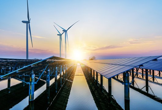 Windkraftwerke und Solarzellen im Sonnenuntergang 