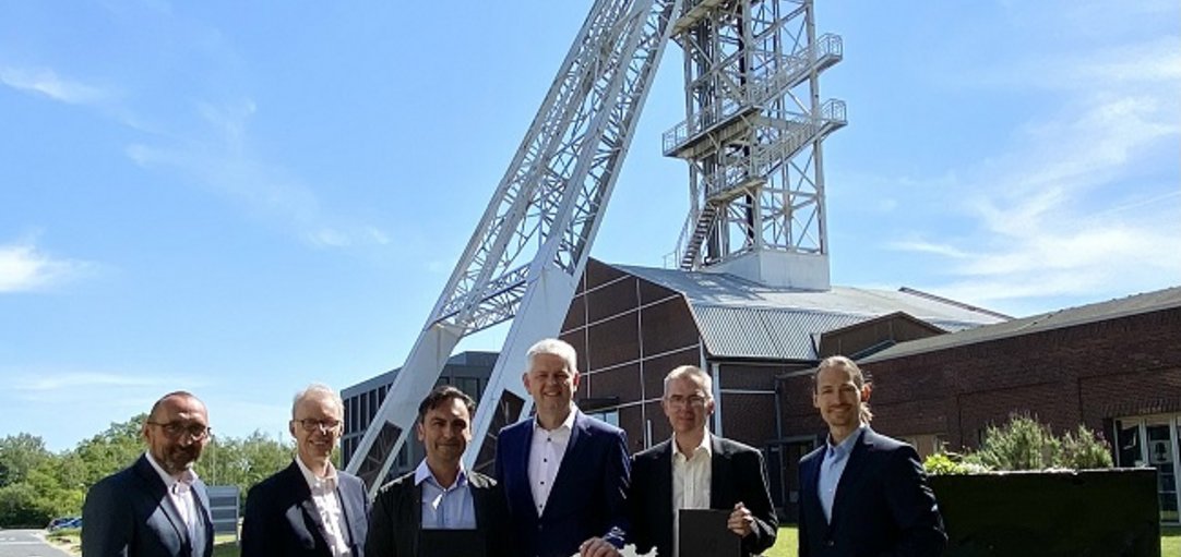 Personen mit Symbol-Förderbescheid vor dem Lüntech-Tower in Lünen.