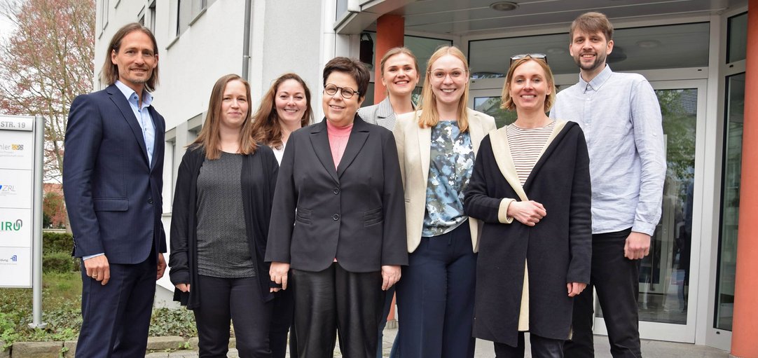 Gruppenfoto Team Fläche, sieben Personen plus Geschäftsführer vor dem WFG-Gebäude.