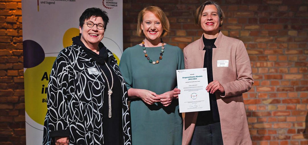 Das Bild zeigt drei Frauen, die eine Urkunde in die Kamera halten.