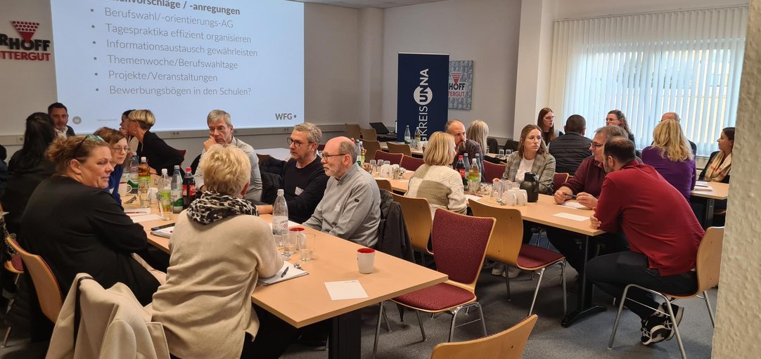Das Bild zeigt eine Gruppe von Menschen in einem Konferenzraum