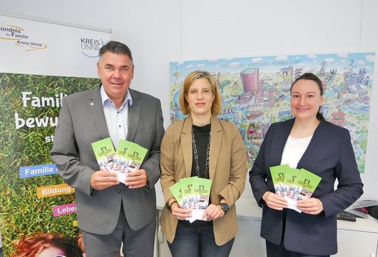 Drei Personen vor dem Roll-up des Bündnisses für Familie. 